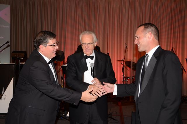 ISBA 3rd Vice President Richard D. Felice accepts the raffle prize from IBF Board member Peter Flowers as M.C. Lester Munson (center) looks on