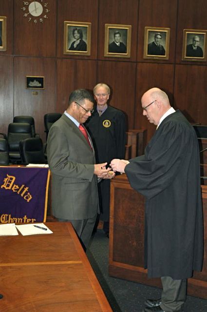 Appellate Court Justice Nathaniel R. Howse, Jr. receives his fraternity pin from Chicago Alumni Chapter Honorary Justice James F. Holderman, Chief Judge of the U.S. District Court, as PAD District XI Justice John K. Norris looks on.  
