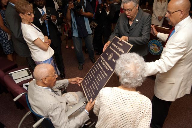 Cook County Board President Toni Preckwinkle and Judge William Hooks present a copy of a permanent building plaque to Judge Leighton.  Judge Leighton's daughter, Barbara Whitfield, and his sister, look on.