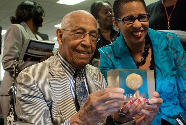 Judge Leighton and Judge Ann Claire Williams display a rock which is encased in plastic, dated March 17, 1936.  That is when Judge Leighton, as a young man, found the rock amidst potatoes he was peeling at a restaurant job.  He decided to keep the rock, and it has accompanied him throughout his life journey. 
