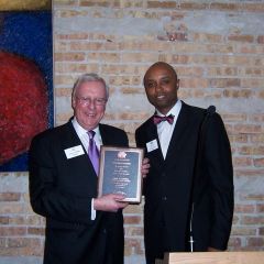 ISBA President John O'Brien receives a commemorative plaque from IBF President Vince Cornelius