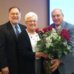  ISBA Executive Director Robert Craghead and President Mark Hassakis present roses to JoAnn Hibbs, Administrative Assistant to the Executive Director during the Board of Governors meeting in St. Louis. Hibbs is retiring from the Association in July after 34 years of service.