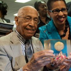 Judge Leighton and Judge Ann Claire Williams display a rock which is encased in plastic, dated March 17, 1936.  That is when Judge Leighton, as a young man, found the rock amidst potatoes he was peeling at a restaurant job.  He decided to keep the rock, and it has accompanied him throughout his life journey. 
