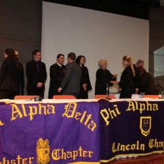 Phi Alpha Delta leaders congratulate each of the new members.